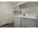 Bright laundry room with washer, dryer, and shelving for organized storage at 19942 N 108Th Ave, Peoria, AZ 85373