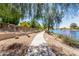 Picturesque walkway bordering the serene lake, lined with lush landscaping for a tranquil outdoor experience at 19942 N 108Th Ave, Peoria, AZ 85373