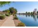 Picturesque view of the community's tranquil lake, showcasing the walking path and lush landscaping alongside the water at 19942 N 108Th Ave, Peoria, AZ 85373