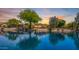 Scenic waterfront view with mature trees and vibrant sky, perfect for tranquil living and enjoying picturesque sunsets at 19942 N 108Th Ave, Peoria, AZ 85373