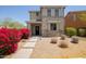 Charming two-story home with stone accents and a walkway lined with vibrant red bougainvillea at 20045 N 49Th Dr, Glendale, AZ 85308