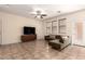 Well-lit living room featuring tile floors, a contemporary sectional sofa, and a media center at 20045 N 49Th Dr, Glendale, AZ 85308