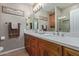 Bright bathroom with double sinks, marble countertops, and a glass enclosed shower at 20420 N 93Rd Dr, Peoria, AZ 85382