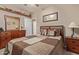 Bedroom featuring a queen bed, ceiling fan, carpet and dresser with mirror at 20420 N 93Rd Dr, Peoria, AZ 85382