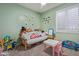 Bright bedroom featuring neutral carpet, a window, and a play area at 20420 N 93Rd Dr, Peoria, AZ 85382