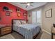 Cozy bedroom featuring carpet, a ceiling fan, shuttered windows and an accent wall at 20420 N 93Rd Dr, Peoria, AZ 85382