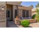 Charming front porch with comfortable seating area framed by tasteful brickwork and lush landscaping at 20420 N 93Rd Dr, Peoria, AZ 85382