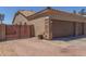 Inviting front view featuring a three car garage with brick accents, large driveway, and meticulously maintained landscaping at 20420 N 93Rd Dr, Peoria, AZ 85382
