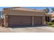 Inviting front view featuring a three car garage with brick accents, large driveway, and meticulously maintained landscaping at 20420 N 93Rd Dr, Peoria, AZ 85382