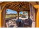 Comfortable gazebo offers an inviting outdoor living space with views of the pool and manicured backyard at 20420 N 93Rd Dr, Peoria, AZ 85382