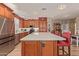 Bright kitchen boasts stainless steel appliances, quartz counters, large island, and wood cabinets at 20420 N 93Rd Dr, Peoria, AZ 85382