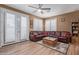 Comfortable living room with tile floors, ceiling fan, a leather sofa, and wooden trunk table at 20420 N 93Rd Dr, Peoria, AZ 85382