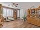 Cozy living room features wood-look floors, a ceiling fan, and plantation shutters for ample natural light at 20420 N 93Rd Dr, Peoria, AZ 85382