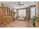 Bright living room showcases stylish wooden furnishings, white plantation shutters, and a ceiling fan at 20420 N 93Rd Dr, Peoria, AZ 85382