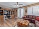 Living room features wood-look floors, TV, and a fireplace, opening to the outside through white doors at 20420 N 93Rd Dr, Peoria, AZ 85382