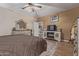 Well-lit main bedroom shows dresser with mirror, electric fireplace, and neutral color palette at 20420 N 93Rd Dr, Peoria, AZ 85382