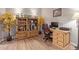 Home office with wood-look floors, desk, rolling chair, and a decorative bookshelf with stylish accents at 20420 N 93Rd Dr, Peoria, AZ 85382