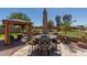 Outdoor patio featuring a dining table with seating, covered gazebo, and a well-maintained landscape at 20420 N 93Rd Dr, Peoria, AZ 85382
