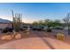 Desert landscaping creates an outdoor oasis, with cacti, shrubs, and a brick patio under a picturesque sunset at 20506 N 271St Ave, Buckeye, AZ 85396