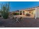 Backyard featuring desert landscaping, a covered patio with an outdoor seating area, and a lush desert vista at 20506 N 271St Ave, Buckeye, AZ 85396