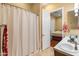 Bright bathroom featuring a double vanity, a shower with a curtain and a bedroom visible through an open door at 20506 N 271St Ave, Buckeye, AZ 85396