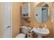 Charming powder room featuring a pedestal sink, decorative mirror, and stylish decor, perfect for guests at 20506 N 271St Ave, Buckeye, AZ 85396