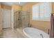 A full bathroom with a separate shower and tub, and plantation shutters at 20506 N 271St Ave, Buckeye, AZ 85396
