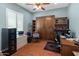 Office/bedroom features built-in Murphy bed and shelving with an attached desk, complemented by hardwood floors and plantation shutters at 20506 N 271St Ave, Buckeye, AZ 85396