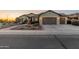 Single-story home with desert landscaping, a paved walkway, and a well-lit two-car garage at 20506 N 271St Ave, Buckeye, AZ 85396