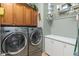 Well-equipped laundry room boasts side-by-side washer and dryer, ample cabinetry, and a convenient folding counter at 20506 N 271St Ave, Buckeye, AZ 85396