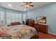 A traditional main bedroom with hardwood floors, plantation shutters, sitting area and a ceiling fan at 20506 N 271St Ave, Buckeye, AZ 85396