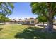 Expansive backyard with a well-manicured lawn and mature shade trees at 21218 N Aurora Dr, Sun City West, AZ 85375