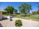 Gravel backyard featuring mature desert landscaping and a concrete patio at 21218 N Aurora Dr, Sun City West, AZ 85375