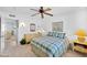 Bedroom with a ceiling fan and neutral carpet with a view into an adjacent room at 21218 N Aurora Dr, Sun City West, AZ 85375