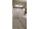 Bright laundry room with white appliances, tile flooring, and desert-themed decor at 21218 N Aurora Dr, Sun City West, AZ 85375
