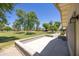 View of the patio and spacious, well-maintained lawn with mature trees at 21218 N Aurora Dr, Sun City West, AZ 85375