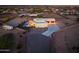 Sprawling property with a private pool, horse stables, and a long driveway at dusk at 2609 W Lavitt Ln, Phoenix, AZ 85086