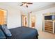 Spacious bedroom featuring a ceiling fan, adjacent rooms, and a dresser with a television at 2609 W Lavitt Ln, Phoenix, AZ 85086