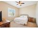 Bedroom featuring a queen bed, ceiling fan, and window with shutter blinds at 2609 W Lavitt Ln, Phoenix, AZ 85086
