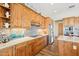 Bright kitchen with knotty wood cabinets, mosaic backsplash, and stainless steel appliances at 2609 W Lavitt Ln, Phoenix, AZ 85086