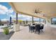 Covered patio with outdoor seating and a dining area, offering a relaxing space overlooking the pool and desert scenery at 2609 W Lavitt Ln, Phoenix, AZ 85086