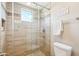 Gorgeous shower with glass door, beige tile surround, and a rain shower head at 2609 W Lavitt Ln, Phoenix, AZ 85086