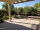 A backyard with a covered patio that features desert landscaping and a secluded outdoor seating area at 2611 E San Paulo Dr, Casa Grande, AZ 85194