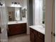 Bathroom featuring separate sink vanities, each with undermount sinks, mirrors, and tiled flooring at 2611 E San Paulo Dr, Casa Grande, AZ 85194
