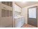 Functional laundry area with washer, dryer, storage cabinets, and exterior access at 2807 W Gregory St, Apache Junction, AZ 85120