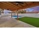 Expansive backyard with a covered patio, artificial grass, and a sparkling swimming pool at 2905 W Campo Bello Dr, Phoenix, AZ 85053