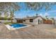 Backyard featuring a sparkling pool, artificial turf, and gravel, creating a serene outdoor oasis at 2905 W Campo Bello Dr, Phoenix, AZ 85053