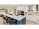 Modern kitchen boasts an island with seating, white cabinets, and stainless steel appliances at 2905 W Campo Bello Dr, Phoenix, AZ 85053