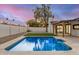 Backyard pool with lush grass, a covered patio, and block wall, perfect for relaxation at 2905 W Campo Bello Dr, Phoenix, AZ 85053