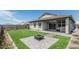 Spacious backyard with a fire pit, lush grass, and a covered patio perfect for outdoor entertaining at 2923 W Shanley Ave, Apache Junction, AZ 85120